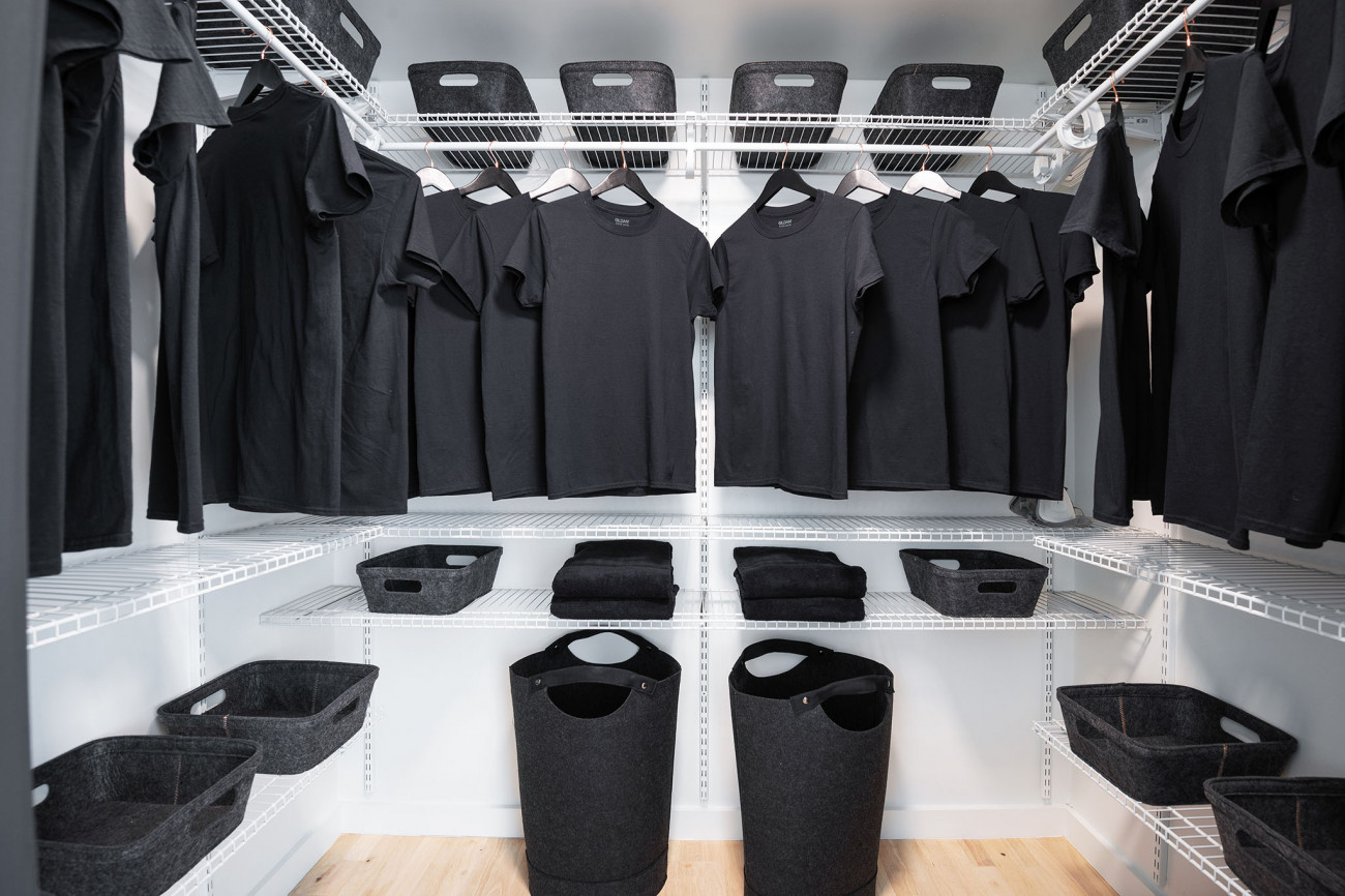 Walk in closet with black t-shirts.